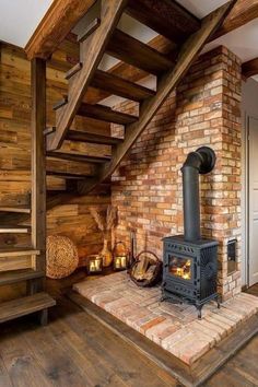 a wood burning stove sitting under a wooden staircase