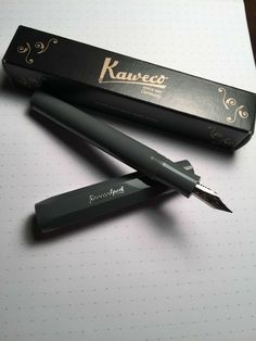 a pen sitting on top of a table next to a box with the writing kaweco