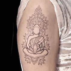 a woman's arm with a tattoo on it that has a buddha in the center