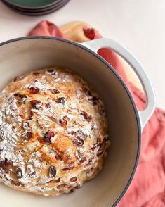 a baked item in a pot on a table next to other dishes and utensils