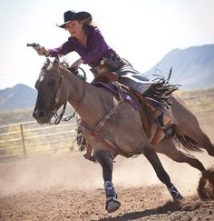 a woman riding on the back of a brown horse