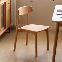 a wooden chair sitting next to a white table