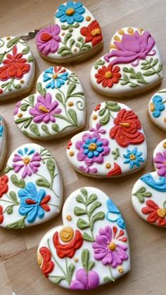 decorated sugar cookies arranged in the shape of hearts and flowers on a wooden table top