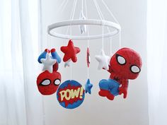 a crib mobile with spiderman, captain america and pow on it