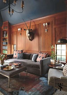 a living room filled with furniture and a deer head mounted on the wall above it