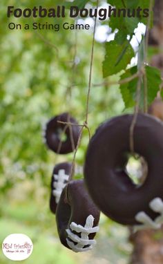 three chocolate donuts hanging from a tree with the words football doughnuts on a string