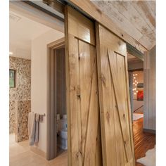 an open door leading to a bathroom with wood floors and walls in the background,