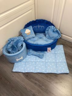 a blue dog bed with pillows and other items