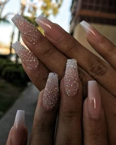 someone is holding their nails with some glitter on them, and there are other manies in