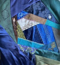 a pile of different colored fabrics on top of each other with one patch in the middle