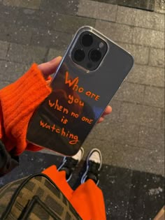 a person holding up a phone case that says, who are you when no one is watching