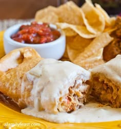 some food is laying out on a plate with chips and salsa in the bowl next to it