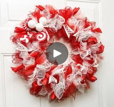 a red and white wreath hanging on the front door