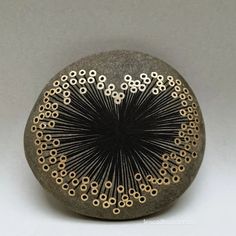 a black and gold object sitting on top of a white surface