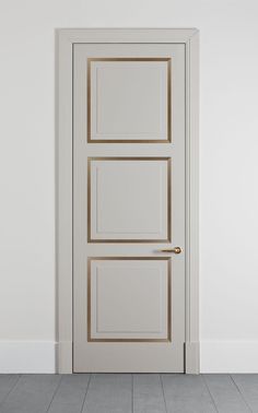 a white door with gold trim in an empty room