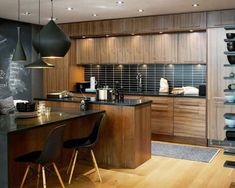 a kitchen with wooden cabinets and black counter tops is pictured in this image, along with two dining chairs