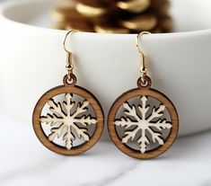 a pair of wooden earrings with snowflakes on them