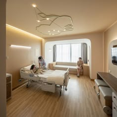 three people in a hospital room with beds