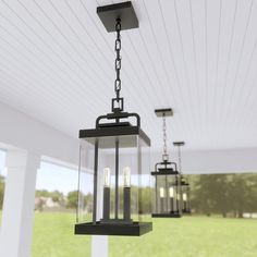 three light fixtures hanging from the ceiling in a room with white walls and green grass