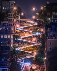 a city street filled with lots of traffic next to tall buildings in the night time