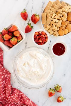 the ingredients to make strawberry shortbread dip laid out on a marble counter top with strawberries and crackers