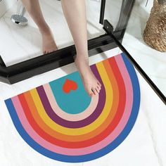 a person standing on top of a rainbow colored rug in front of a bathroom mirror