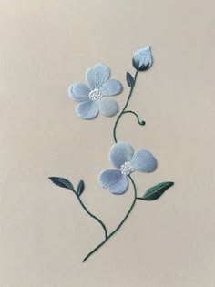 three blue flowers with green leaves on a white background