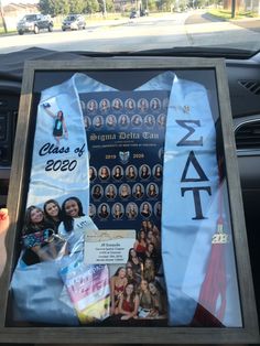 a car dashboard with a poster on it that reads class of 2020 and has pictures of women in them