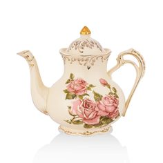 a white tea pot with pink roses painted on the side and gold trimmings