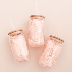 three glass jars filled with cotton swaddles and the words love are on them