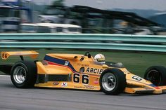 a man driving a yellow race car down a track