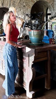 a woman standing next to a table with a bowl on it