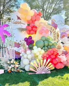 an assortment of balloons and decorations on the grass