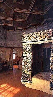 the room is very large and has many paintings on the walls, including an elaborately decorated fireplace