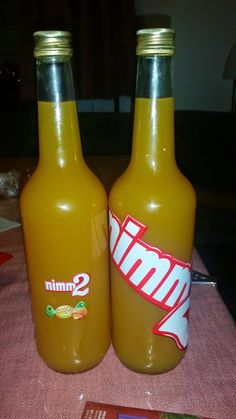 two orange soda bottles sitting on top of a table