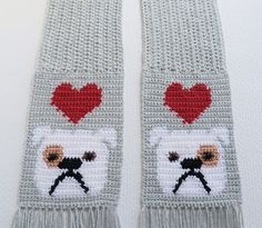 Crochet bulldog scarf. Handmade, light gray scarf featuring our English bulldogs and red hearts. The scarf is hand crocheted with very soft yarn and has a lightweight, flexible drape. The bulldogs are crocheted with white and have a caramel color spot around one eye. The eyes are chocolate brown and black and the nose and mouths are black. The hearts are crocheted with really red color yarn. Scarf is very well made and all loose ends are sewn in. The last photograph shows the back side of the sc Crochet Bulldog, Crochet Paw Print, Yarn Scarf, Gray Crochet, Scarf Handmade, Loose Ends, English Bulldogs, Grey Scarf, Caramel Color