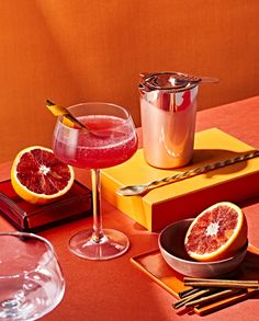 a table topped with plates and glasses filled with drinks next to orange slices on top of each other