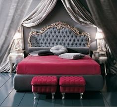 a bedroom with a red bed and two stools in front of the headboard