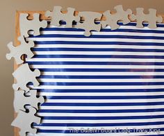 a piece of puzzle sitting on top of a blue and white striped wall next to a wooden frame