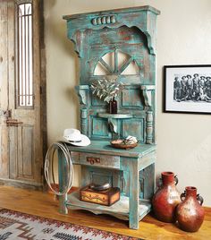 an old wooden hutch sitting on top of a hard wood floor next to vases