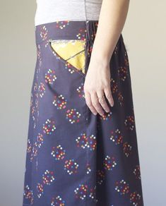 a woman is wearing a skirt with colorful dots on it and has her hand in the pocket