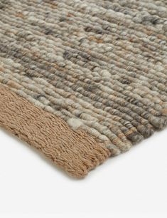 a close up view of a rug with brown and beige colors on it, showing the texture