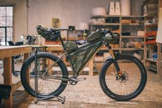 a bike parked inside of a garage next to a workbench with tools on it