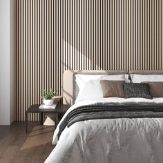 a large bed sitting in a bedroom next to a wall with vertical stripes on it