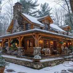 a log cabin in the winter with snow on the ground and lights on it's windows