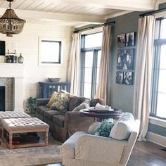 a living room with couches, chairs and a fire place in the center area