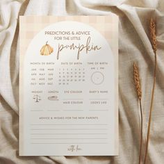 a paper calendar on top of a bed next to some dried grass and flowers in front of it