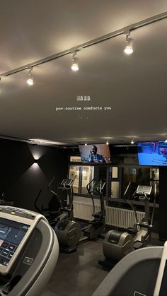 there are many treadmills in the gym with tvs on them and other equipment