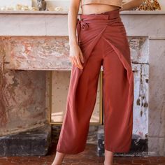 a woman standing in front of a fireplace with her hands on her hips and looking at the camera