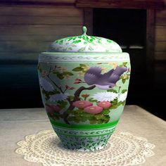 a green and white vase sitting on top of a table